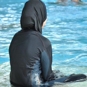 ARCHIV - ILLUSTRATION - Eine muslimische Schülerin sitzt am 23.06.2009 in einem Ganzkörper-Badeanzug am Rande des Schwimmbeckens. Eine in Frankreich geborene Muslimin kam in ihrem Burkini in einem Schwimmbad in Emerainville bei Paris nicht am Bademeister vorbei. Die junge Frau musste die Badeanstalt wieder verlassen. Nach ihrem nach Rauswurf aus dem Schwimmbad gibt sie zur Polizei und zur Staatsanwaltschaft, um ihr Baderecht im Burkini durchzusetzen. Foto: Rolf Haid (zu dpa 0355 vom 12.08.2009) +++(c) dpa - Bildfunk+++